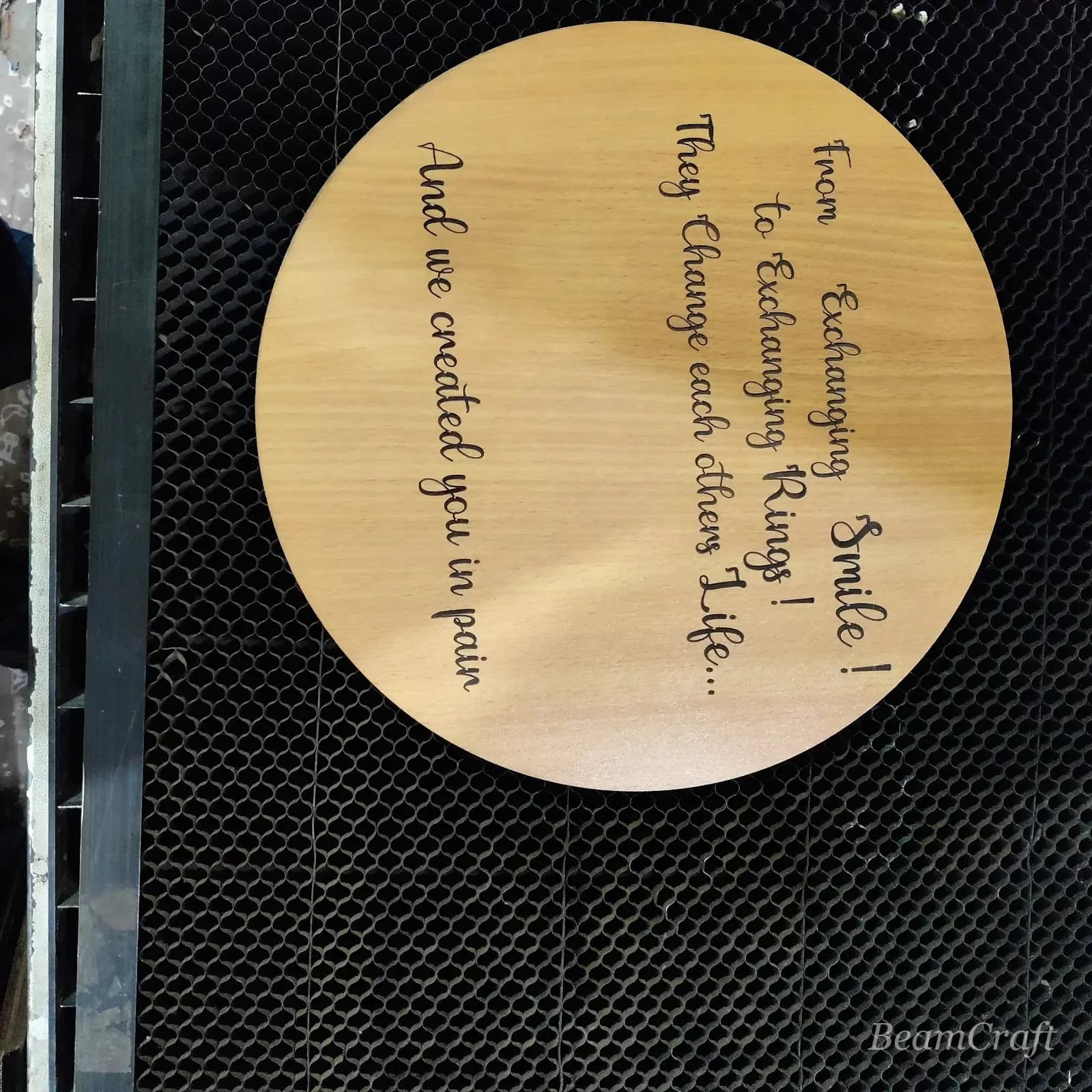 Macro of laser-engraved script on a light wooden disc